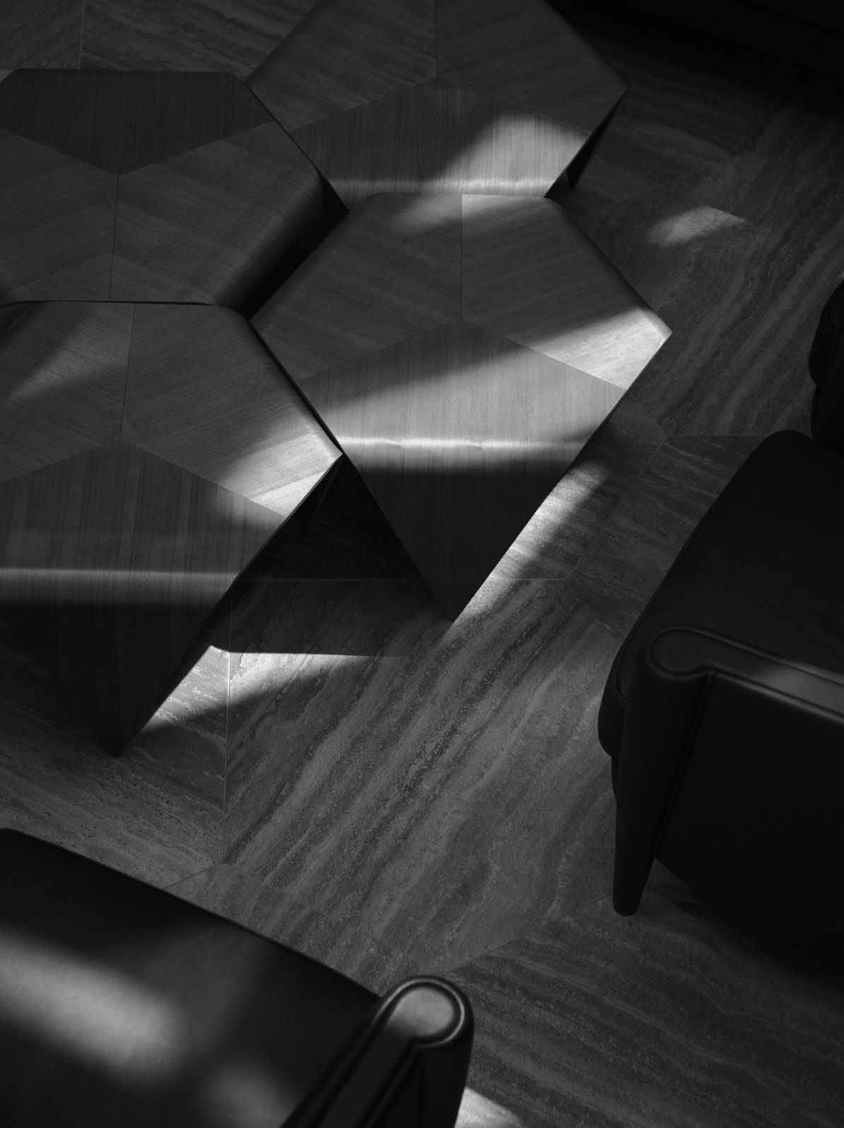 A monochrome image highlighting the interplay of light and shadow on a geometrically patterned floor with elegant furniture