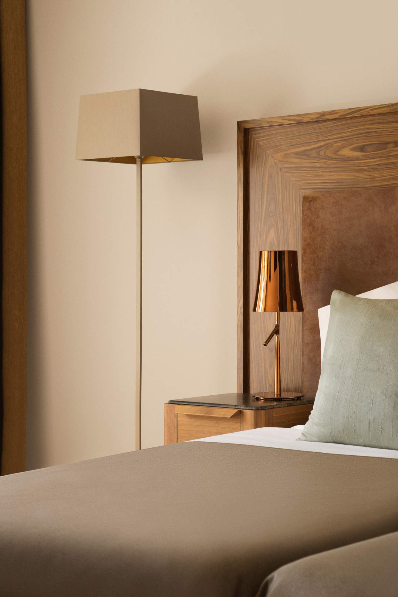 A hotel room with a bed, headboard, and bedside lamp, exuding warmth and comfort