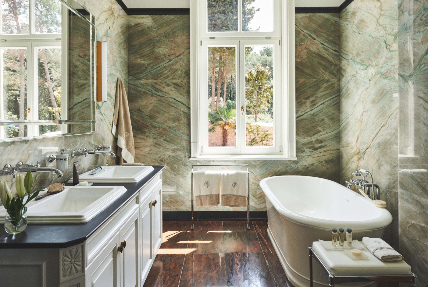 Spacious bathroom featuring double vanities with sleek faucets and a luxurious soaking bathtub